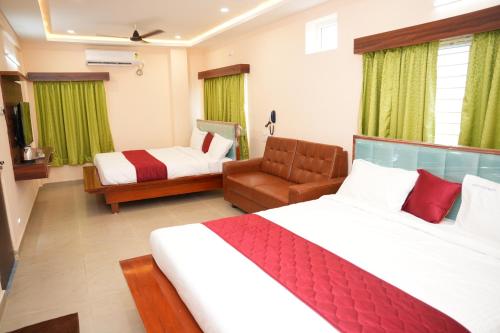 a hotel room with a large bed and a couch at Hotal Virinchi Ultra Comforts - Good Rooms - Brand New Building in Tirupati