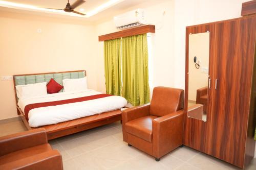 a bedroom with a bed and a chair at Hotal Virinchi Ultra Comforts - Good Rooms - Brand New Building in Tirupati