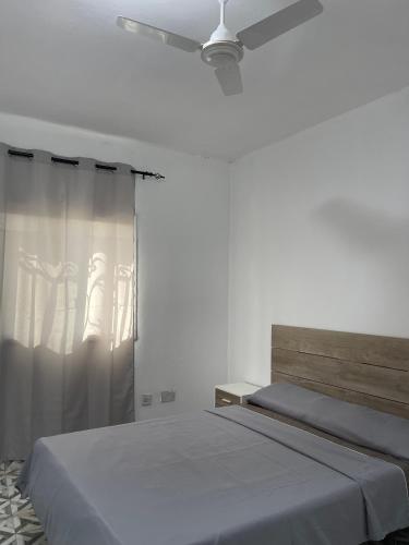 a bedroom with two beds and a ceiling fan at Seven Apartments in Serekunda
