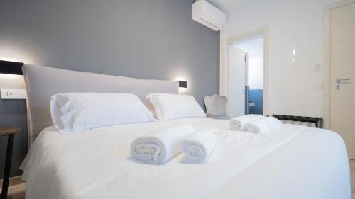 a white bed with towels on top of it at Modern Room in Olbia