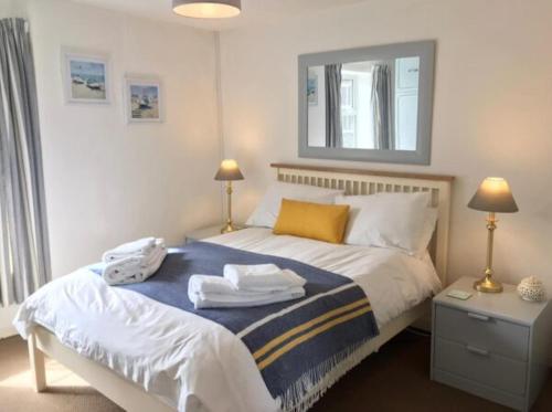 a bedroom with a bed with towels on it at Norfolk Chapel Cottages in Docking