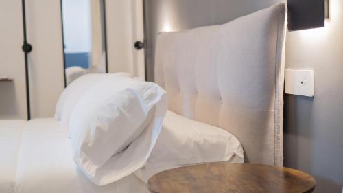 a bed with white pillows and a table in a room at Modern Room in Olbia