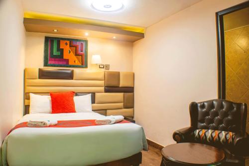 a hotel room with a bed and a chair at Hotel Royal Qosqo in Cusco