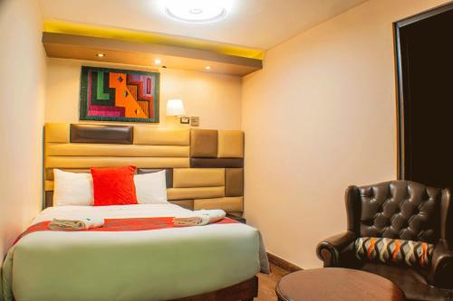 a hotel room with a bed and a chair at Hotel Royal Qosqo in Cusco