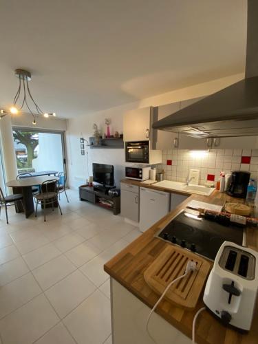 une cuisine avec un comptoir et une table à l'intérieur dans l'établissement Apt 4 pers- Terrasse vue mer, 150 m de la plage - GILDWEN, à Kervernoïs