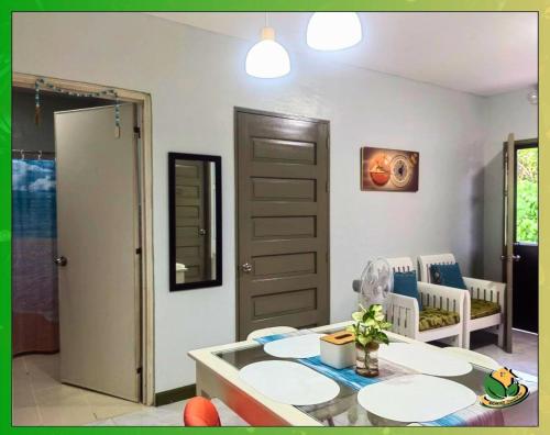 ein Wohnzimmer mit einem Tisch, Stühlen und einer Tür in der Unterkunft Homey 2BR Apartment with Essentials & Modern Decor - Richkizz in Puerto Princesa