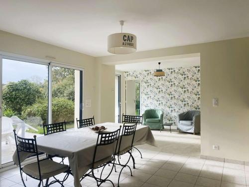 une salle à manger avec une table et des chaises ainsi qu'un panneau indiquant la voiture dans l'établissement Maison lumineuse 3 étoiles, proche plages, 4 chambres, terrasse et jardin à Beg-Meil - FR-1-481-84, à Fouesnant