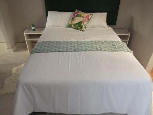 a bed with a white comforter and two pillows at Vumasky self catering in Ladysmith