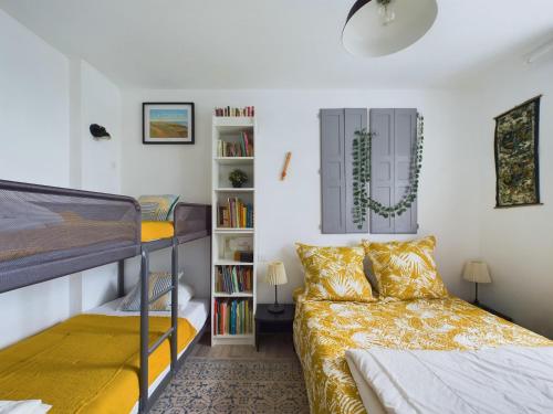 une chambre avec un lit et un lit superposé dans l'établissement Douce escapade avec jardin à 800m de la plage, à Saint-Hilaire-de-Riez