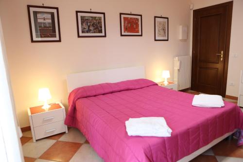 a bedroom with a large pink bed with two lamps at Centauro by PizzoApartments in Pizzo