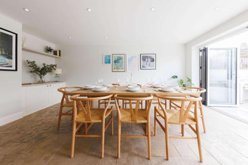 a kitchen and dining room with a wooden table and chairs at Chic 4-Bed Coastal Retreat in Heart of Bosham in Bosham