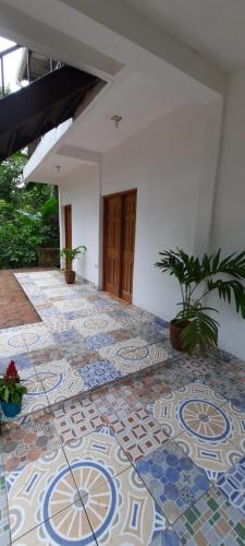 a room with a tiled floor with plants on it at La Casa de Leo - Hostal, Restaurante y Artesania local in San Juan de Oriente