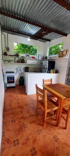 a kitchen with a wooden table and chairs in a room at La Casa de Leo - Hostal, Restaurante y Artesania local in San Juan de Oriente