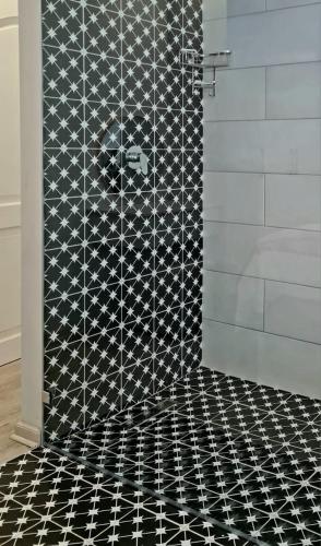 a shower with a black and white tiled floor at Montagu Villa 2 in Mossel Bay