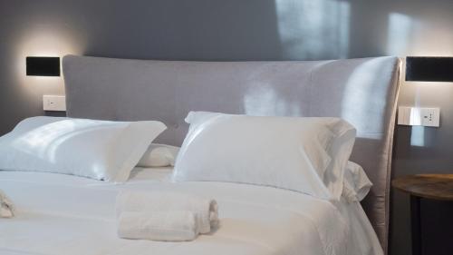 a white bed with white pillows and a stuffed animal on it at Modern Room in Olbia