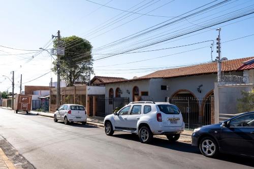 two cars parked on the side of a street at Studio equipado na area central com Wi-Fi in Alfenas