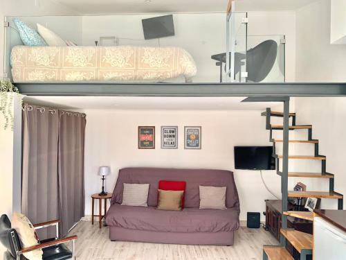 a living room with a purple couch and a bunk bed at Cozy studio house with private terrace in Cascais in Alcabideche