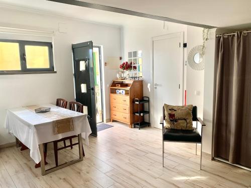 a living room with a table and a chair at Cozy studio house with private terrace in Cascais in Alcabideche