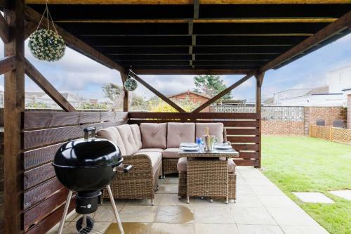 a gazebo with a couch and a grill at Home from home 3-Bed Nr East Wittering Beach in East Wittering