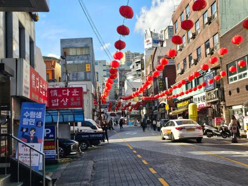 a street with red lanterns on a city street at Busan Subway 6min #2 Rooms #2 Queen Beds #Hotel Bedding #OTT #Table#1st Floor in Busan