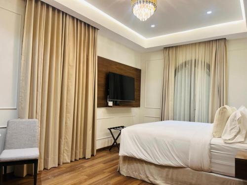 a hotel room with a bed and a tv at Hotel Casa Ensenada Luxury Boutique Hotel in Mexico City