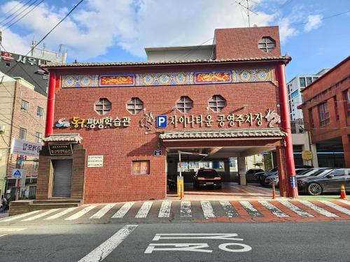 a red brick building with a sign on it at Busan Subway 6min #2 Rooms #2 Queen Beds #Hotel Bedding #OTT #Table#1st Floor in Busan
