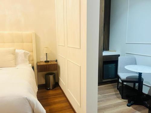 a bedroom with a bed and a table and a chair at Hotel Casa Ensenada Luxury Boutique Hotel in Mexico City