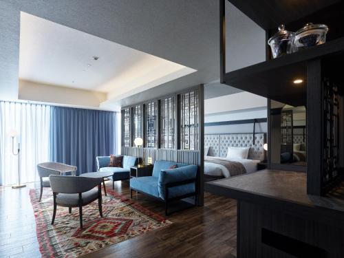 a bedroom with a bed and a living room at Mitsui Garden Hotel Sapporo West in Sapporo