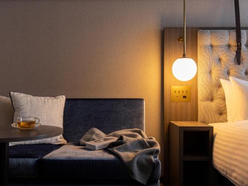 a bedroom with a bed and a table with a blanket at Mitsui Garden Hotel Sapporo West in Sapporo