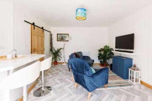 a living room with two chairs and a television at Cosy Cabin Retreat Close to Beaches in Birdham