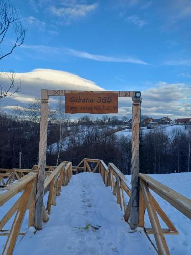 a sign on a wooden bridge in the snow at CABANA 365 in Braşov