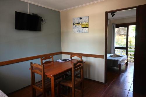 a dining room with a table and chairs and a television at Hotel Mirador del Dayman in Termas del Daymán