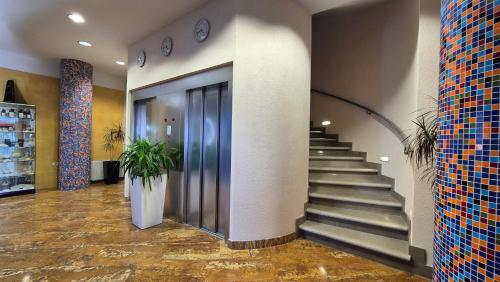 a lobby with stairs and elevators in a building at Hotel Oleander - Oleander Resort in Strunjan