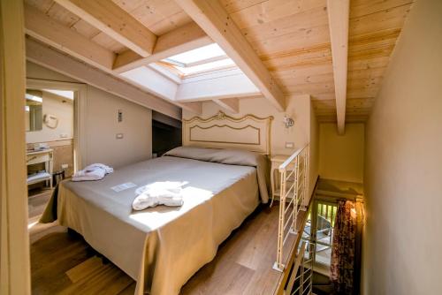 een slaapkamer met een bed en een dakraam bij Garda Apartments San Vigilio Golf in Pozzolengo