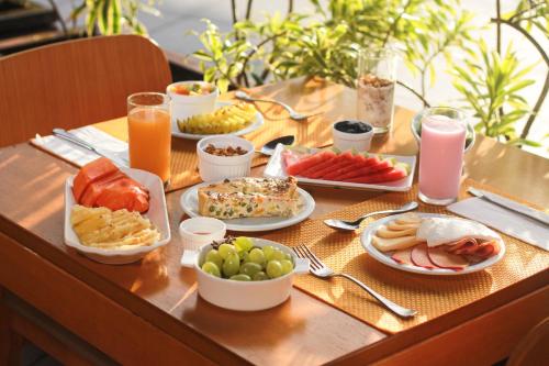 a table topped with plates of food and drinks at Enotel Porto de Galinhas All Inclusive in Porto De Galinhas