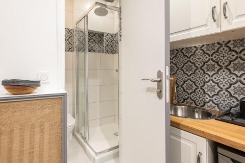 une salle de bain avec un lavabo et une douche dans l'établissement Raymond - Cosy studio proche Montparnasse, à Paris