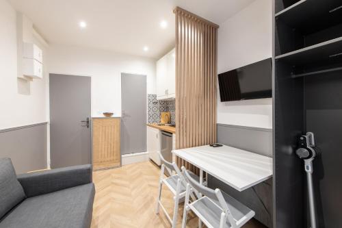 une petite cuisine avec une table et des chaises dans une pièce dans l'établissement Raymond - Cosy studio proche Montparnasse, à Paris