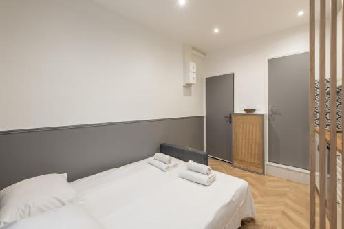 une chambre avec un lit avec deux serviettes dessus dans l'établissement Raymond - Cosy studio proche Montparnasse, à Paris