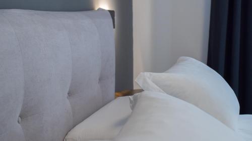 a bed with white sheets and pillows at Modern Room in Olbia