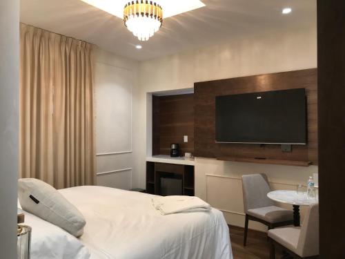 a hotel room with a bed and a flat screen tv at Hotel Casa Ensenada Luxury Boutique Hotel in Mexico City