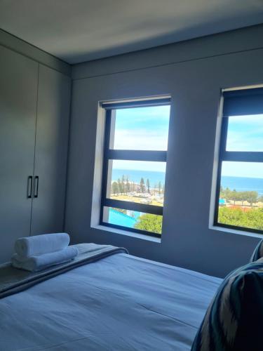 a bedroom with two windows and a bed in it at Montagu Villa 3 in Mossel Bay