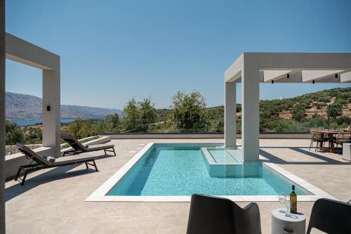 a swimming pool on a patio with a table and chairs at Sunny Vacay Villa in Stérnai