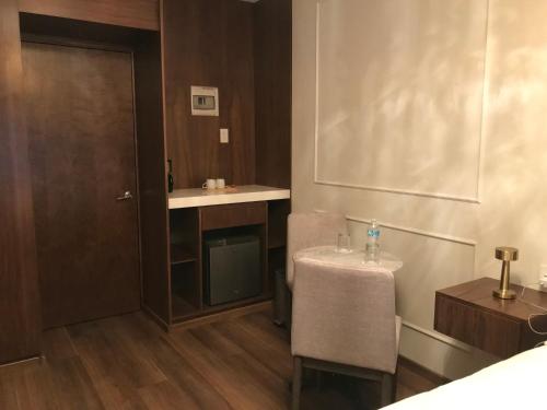 a bathroom with a sink and a table with a chair at Hotel Casa Ensenada Luxury Boutique Hotel in Mexico City