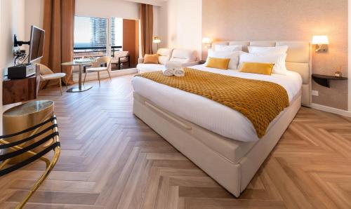 a hotel room with a large bed and a living room at MONACO Border LUXURY SUITE - SEA VIEW - POOL in Beausoleil