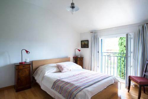 une chambre avec un lit et une grande fenêtre dans l'établissement Domaine La Grange, à Gabian