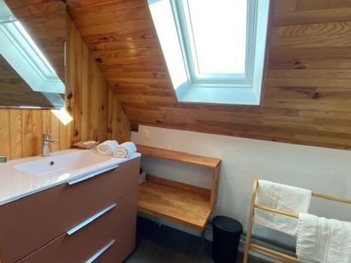 La salle de bains est pourvue d'un lavabo et d'une lucarne. dans l'établissement Maison de vacances 3 étoiles avec jardin à Trégastel, proche plage - FR-1-542-62, à Trégastel