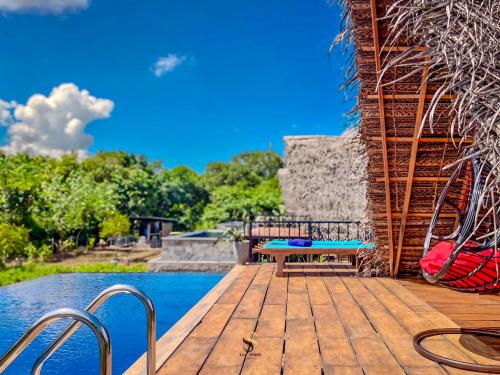 a wooden deck next to a swimming pool at Habarana Tree House Ambasewana Resort in Habarana