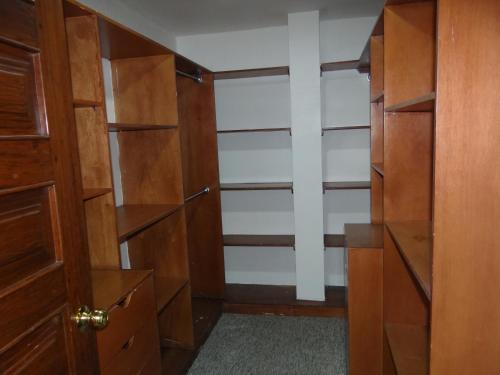 a walk in closet with wooden doors and shelves at Altura Rooms & Suites in Quito