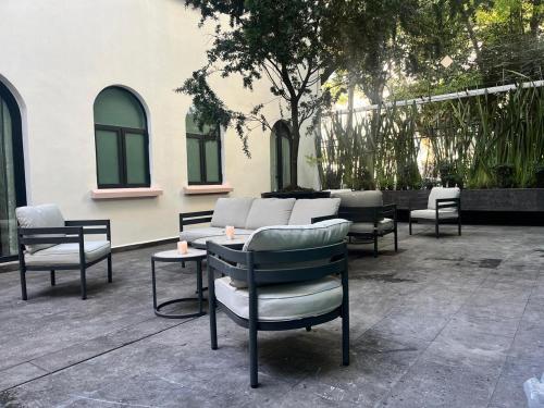 a group of chairs and tables on a patio at Hotel Casa Ensenada Luxury Boutique Hotel in Mexico City
