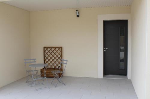 a patio with a table and chairs and a door at Althéa, gîte de charme et bien être in Fontenay-le-Comte
